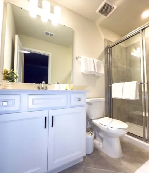 Banheiro moderno com acabamento elegante, bancada ampla e box em vidro, projetado para unir funcionalidade e sofisticação.