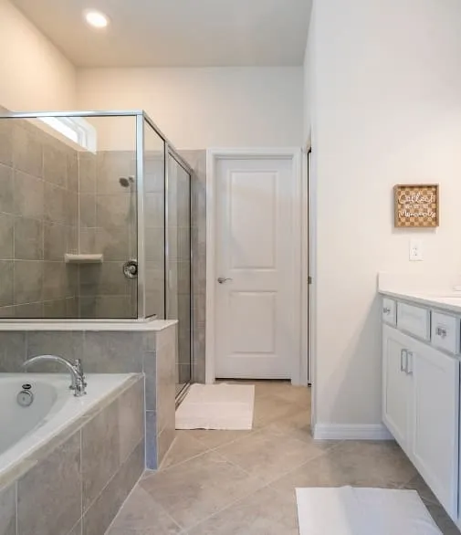 Banheiro moderno com box de vidro, banheira integrada e acabamento em revestimento premium, pensado para unir conforto e elegância.